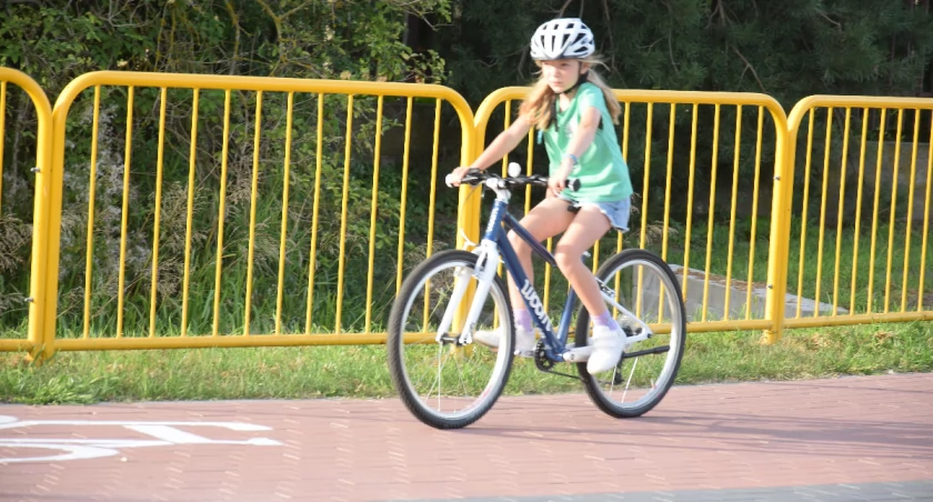 Na zdjęciu rowerzystka w kasku i na ścieżce rowerowej